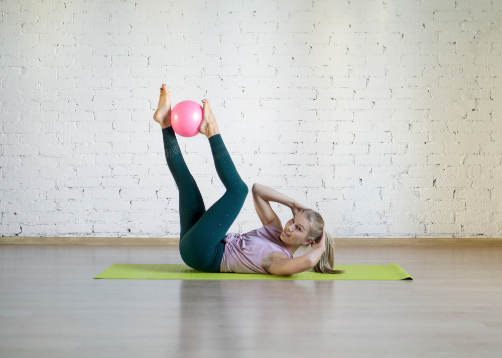 Pilates abs exercise with small fit ball. Caucasian woman doing workout in fitness studio. Gymnastics, yoga, abdominal, healthy spine, sport, smart body and wellness concept