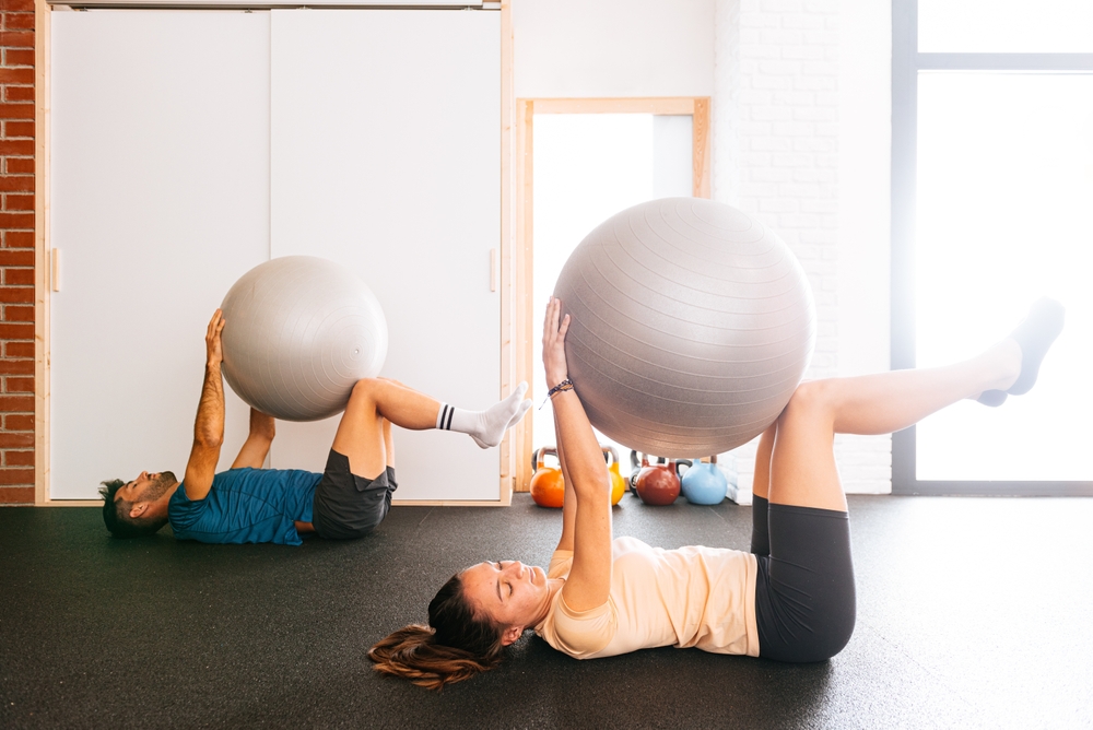 Pilates can be challenging. Shot of a young woman doing core exercises using a medicine ball.